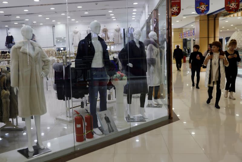 People look at mink fur coats in a store selling mink fur clothing at a shopping mall in Shangcun