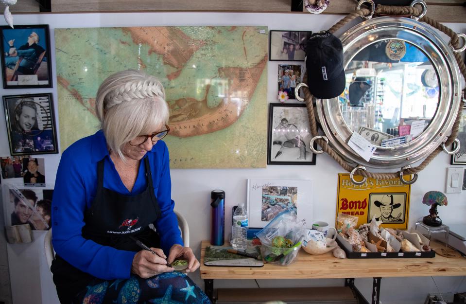 Sharon Welker paints a shell while working at her shop, Tuttles Seahorse Shell Shop, on Monday, Feb. 12, 2024, on Sanibel Island. Welker is an admin for the Sanibel Shells Facebook group.