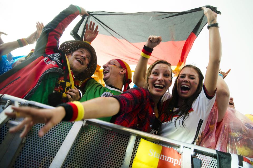 German fans celebrate as their team scores against the U.S. during their 2014 World Cup Group G soccer match, at the Fanmeile public viewing arena in Berlin June 26, 2014. REUTERS/Thomas Peter (GERMANY - Tags: SPORT SOCCER WORLD CUP)