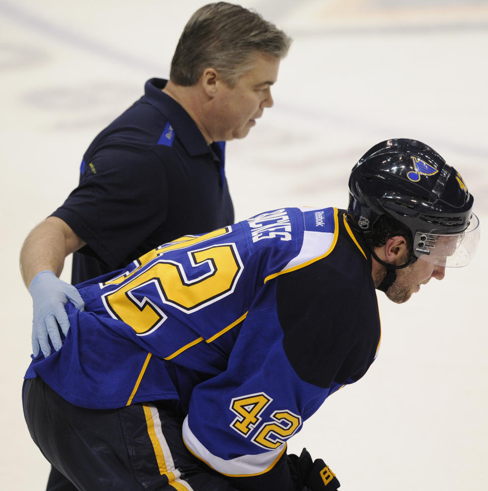 St. Louis Blues' David Backes (42) is helped off the ice by a Blues trainer against the Chicago Blackhawks during the third period in Game 2 of a first-round NHL hockey playoff series, Saturday, April 19, 2014, in St. Louis. (AP Photo/Bill Boyce)