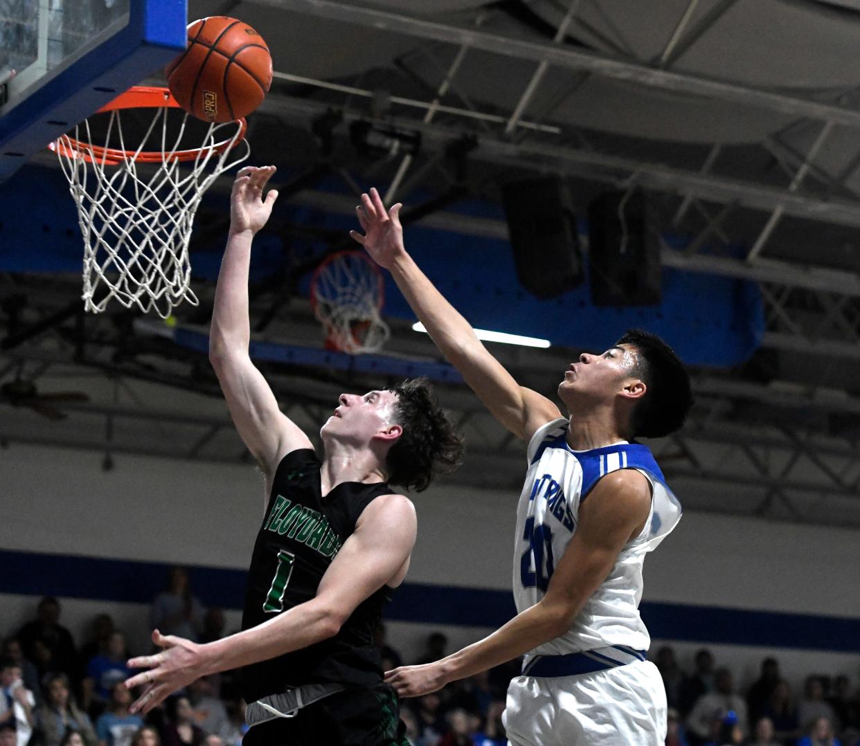 Floydada's Braun Hobbs, left, goes for a layup in front of Olton's Jimmy Munoz in a District 4-2A boys basketball game, Friday, Jan. 13, 2023, at Olton Memorial Gymnasium in Olton.