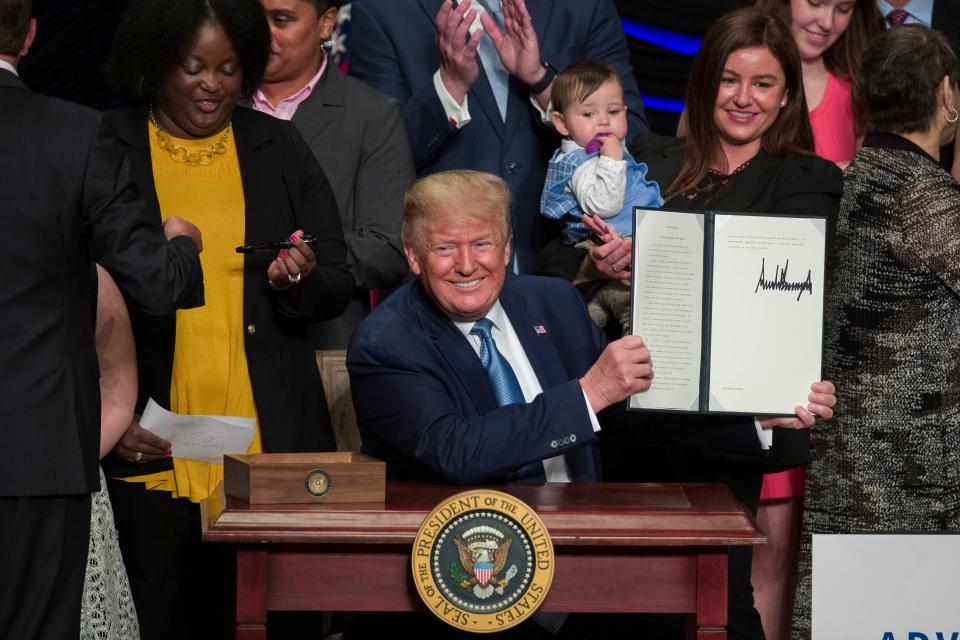 President Donald Trump holds up a signed executive order about kidney health at the Ronald Reagan Building and International Trade Center, Wednesday, July 10, 2019, in Washington.