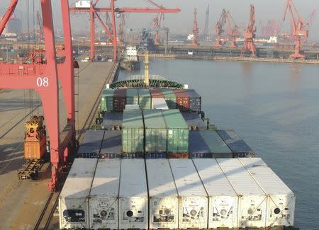 Shipping containers are being loaded onto a cargo ship at a port in Lianyungang, Jiangsu province, China, January 13, 2016. REUTERS/China Daily