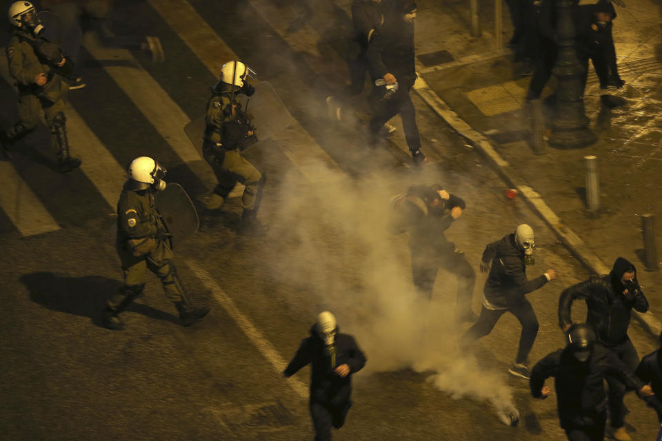 Greek riot police throw tear gas grenades during clashes with demonstrators opponents of Prespa Agreement outside the Greek Parliament in Athens, Thursday, Jan. 24, 2019. Greek lawmakers are debating a historic agreement aimed at normalizing relations with Macedonia in a stormy parliamentary session scheduled to culminate in Friday vote. (AP Photo/Petros Giannakouris)