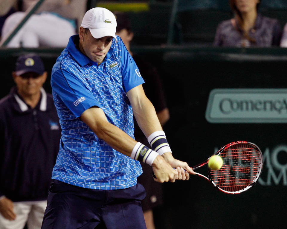 John Isner, of the United States, hits a return to Dustin Brown, of Germany, at the U.S. Men's Clay Court Championship tennis tournament, Wednesday, April 9, 2014, in Houston. (AP Photo/Houston Chronicle, Bob Levey) MANDATORY CREDIT