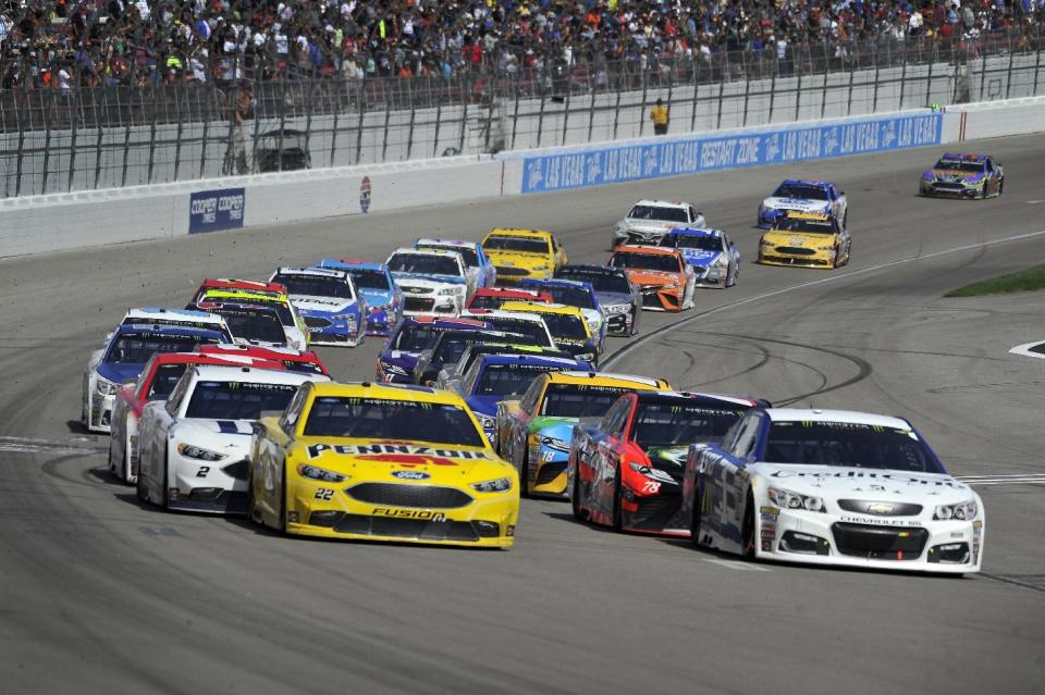 Joey Logano (22) and Jamie McMurray (1) lead the pack as they come out of a caution lap during a NASCAR Cup Series auto race Sunday, March 12, 2017, in Las Vegas. (AP Photo/David Becker)