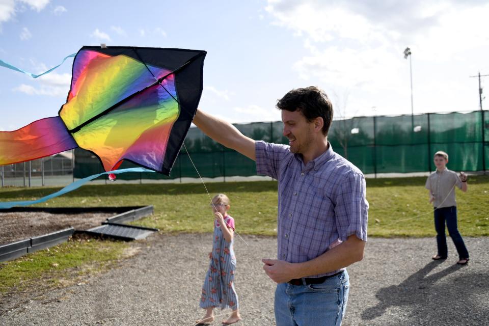 Matthew Kauffman of Canton carries a kite for kids Luana, 8 and Easton, 11, during a family outing at Weis Park in Canton.  Thursday,  February 23, 2023.