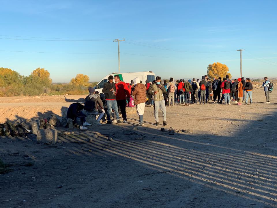 A Border Patrol agent from the Yuma Sector processes a group of migrants who walked across the Colorado River to turn themselves in for a chance to claim asylum in the United States on Dec. 22, 2022.