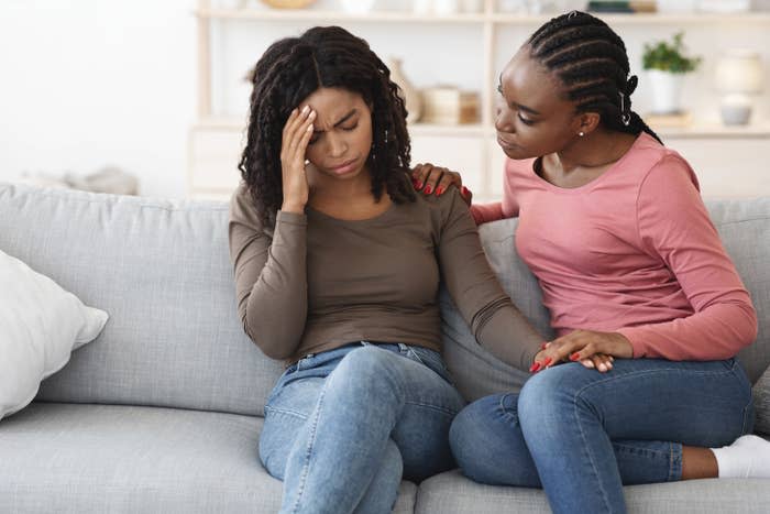 A friend comforting another friend on their couch