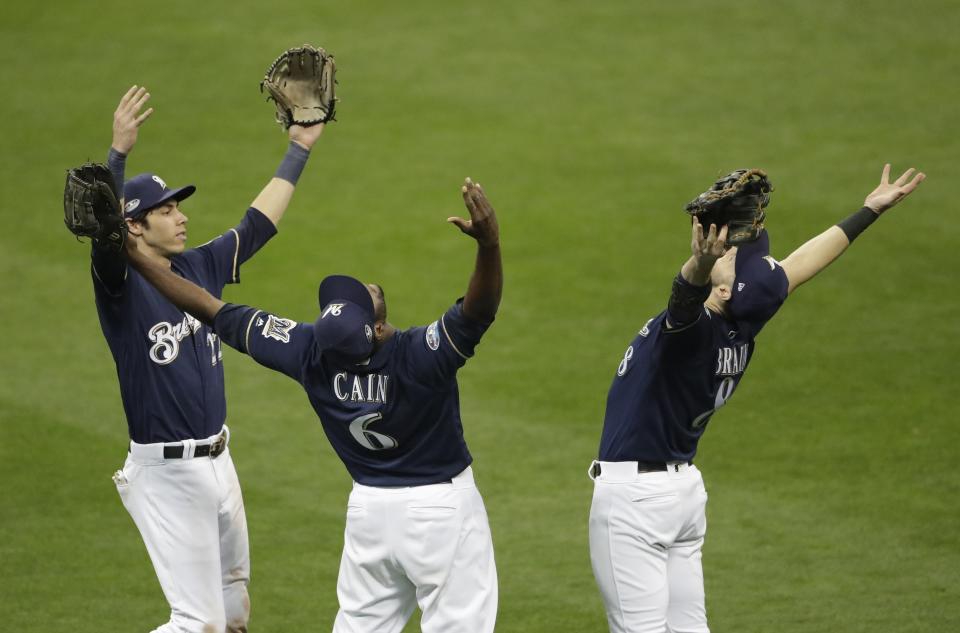 Milwaukee Brewers' Christian Yelich, Lorenzo Cain and Ryan Braun celebrate after Game 2 of the National League Divisional Series baseball game Friday, Oct. 5, 2018, in Milwaukee.The Brewersb won 4-0 to take a 2-0 lead in the series. (AP Photo/Aaron Gash)