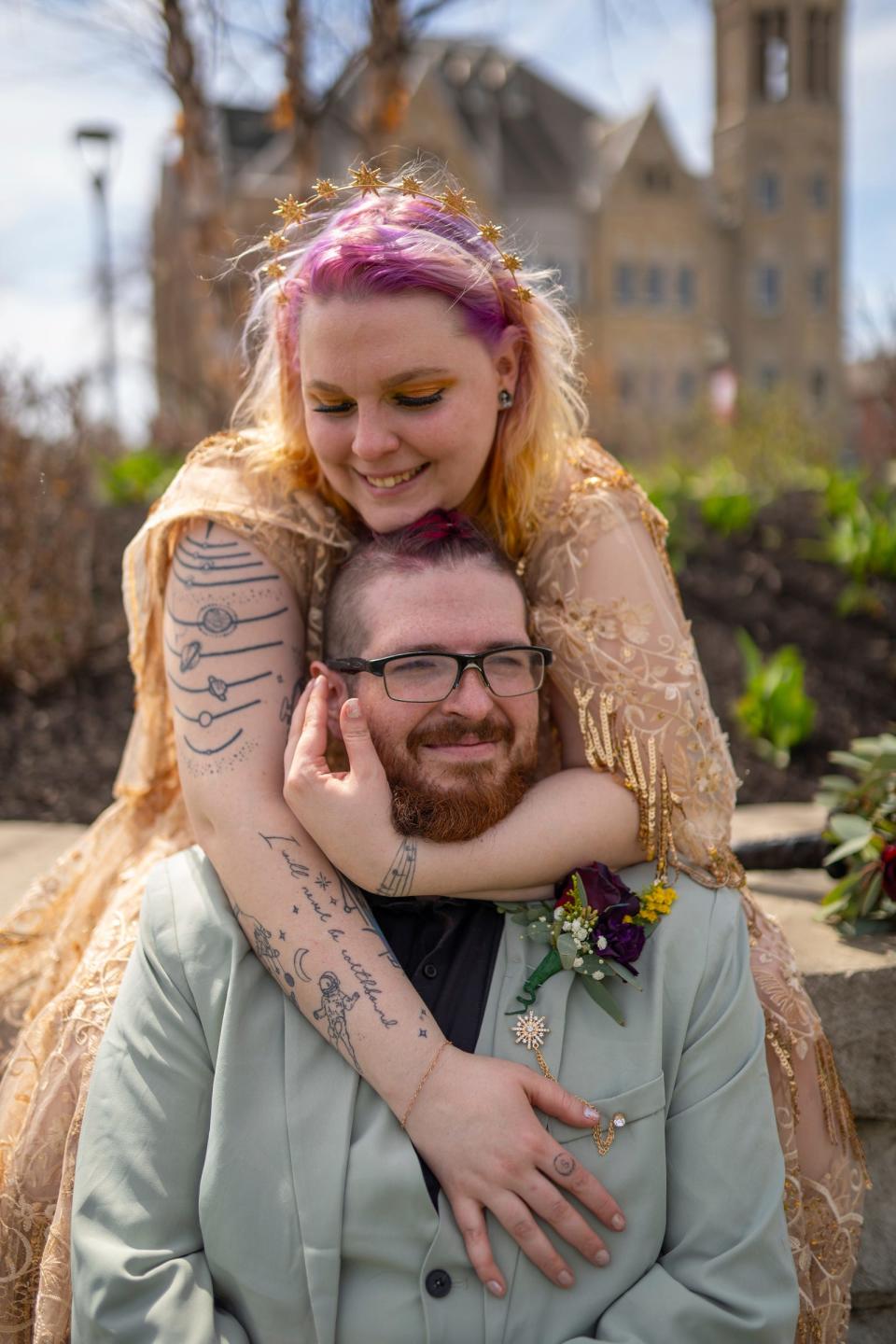 Parker Miller, of Sault Ste. Marie, is hugged by his wife, Erin Miller, of Sault Ste. Marie, while posing for a photo before getting married during the Elope at the Eclipse event at the Frost Kalnow Amphitheater in Tiffin, Ohio, on Monday, April 8, 2024. Over 100 couples and their families gathered to be married or renew their vows during the totality of the eclipse event.