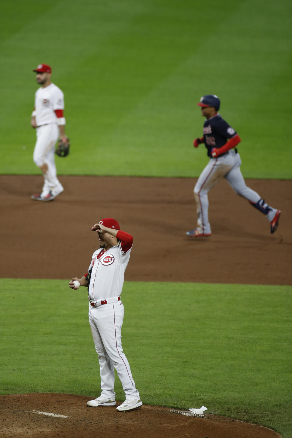 Washington Nationals' Juan Soto, top right, rounds the bases after hitting a home run against Cincinnati Reds' Luis Castillo, foreground, during the sixth inning of a baseball game Thursday, Sept. 23, 2021, in Cincinnati. (AP Photo/Jay LaPrete)