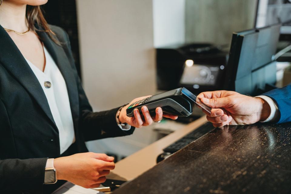 A businessman is paying with credit card at the hotel reception