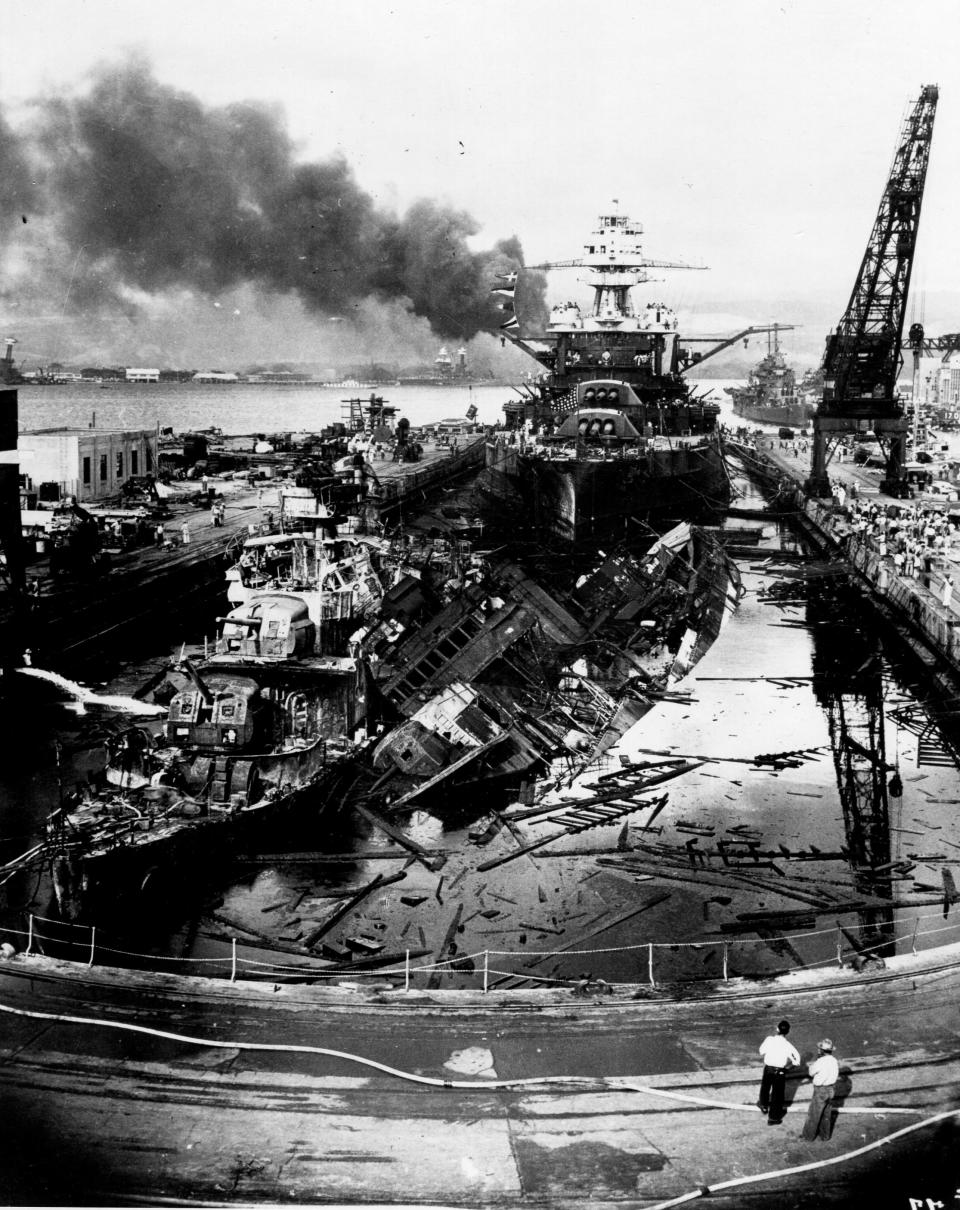 The wrecked destroyers USS Downes and USS Cassin in Drydock One at the Pearl Harbor Navy Yard, soon after the end of the Japanese air attack on Dec. 7, 1941. Cassin has capsized against Downes. USS Pennsylvania is astern, occupying the rest of the drydock.