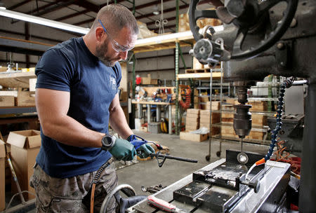 Rodger Brown cleans away fragments after drilling the front sight post assembly for an AR-15 style rifle barrel at Spike's Tactical LLC, a gunmaker in Apopka, Florida, U.S. December 10, 2018. Picture taken December 10, 2018. REUTERS/Gregg Newton