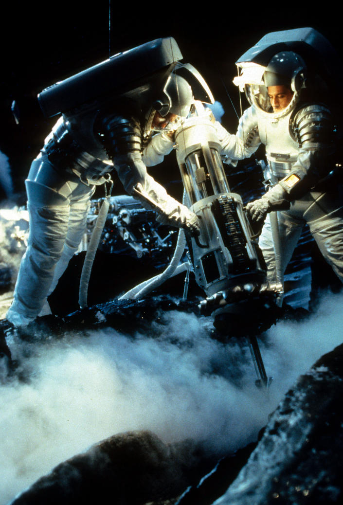 Two men in space suits use a machine in a scene from the film 