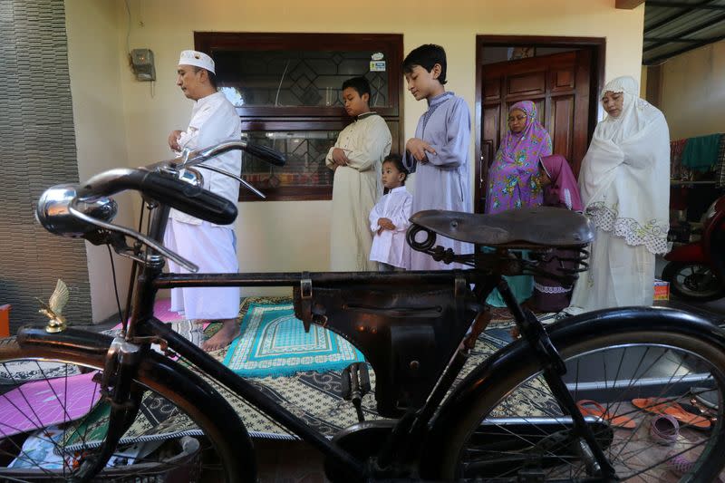 Indonesian Muslims take part in prayers during Eid al-Fitr, the Muslim festival marking the end the holy fasting month of Ramadan, at a their home amid the spread of coronavirus disease (COVID-19)