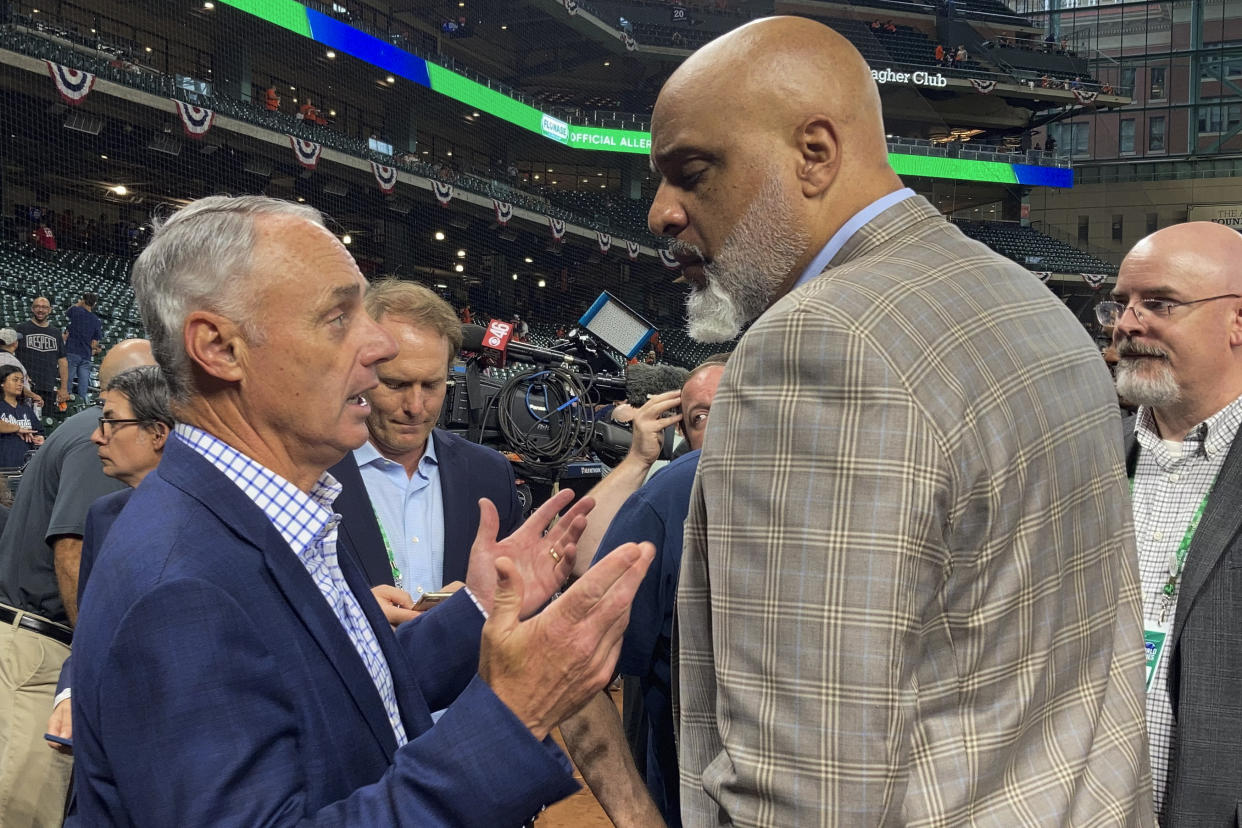 Baseball Commissioner Rob Manfred and Major League Baseball Players Association executive director Tony Clark speak before Game 1 in baseball's World Series against the Atlanta Braves Tuesday, Oct. 26, 2021, in Houston. (AP Photo/Ron Blum)