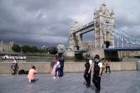 FILE - In this July 3, 2021, file photo, policemen patrol near Tower Bridge as a bride is photographed on the bank of Thames river in London. Britain's Conservative government is hoping a combination of relatively high vaccination rates and common-sense behavior will keep a lid on coronavirus infections this fall and winter and avoid the need for restrictive measures. (AP Photo/Thanassis Stavrakis, File)