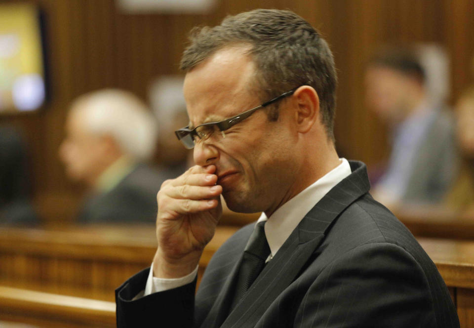 Oscar Pistorius rubs his face as he listens to cross questioning about the events surrounding the shooting death of his girlfriend Reeva Steenkamp, in court during his trial in Pretoria, South Africa, Tuesday, March 11, 2014. Pistorius is charged with the shooting death of Steenkamp, on Valentines Day in 2013. (AP Photo/Kim Ludbrook, Pool)