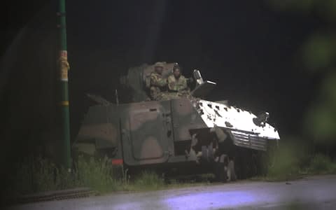 Armed Zimbabwean soldiers sit on top of a military tank in Harare in the early hours of Wednesday - Credit: AP