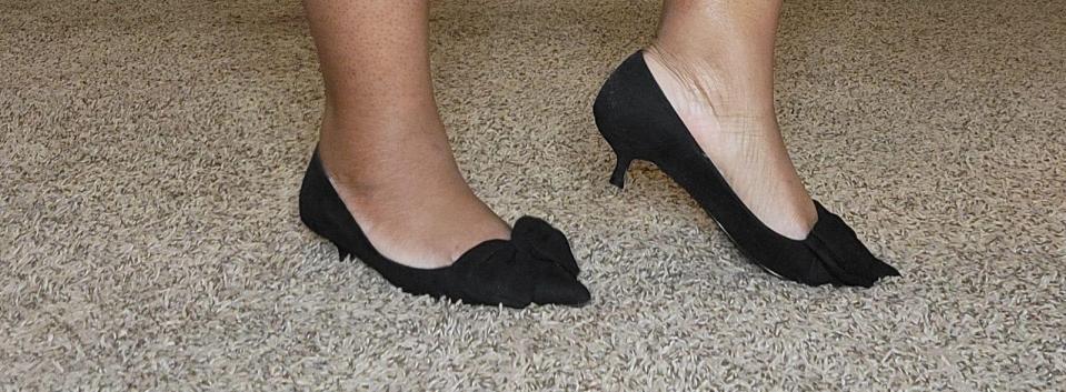 A close-up of the writers kitten heels with a bow
