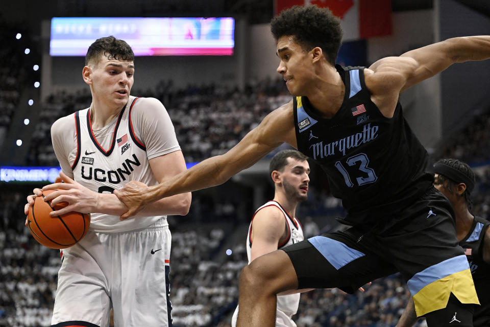 Marquette forward Oso Ighodaro, right, pressures UConn center Donovan Clingan in the second half of an NCAA college basketball game, Saturday, Feb. 17, 2024, in Hartford, Conn. (AP Photo/Jessica Hill)