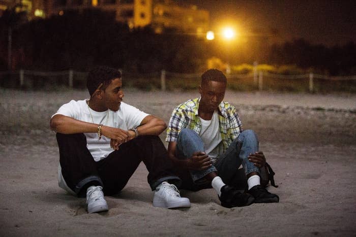 jerome sitting on the ground with another actor in scene