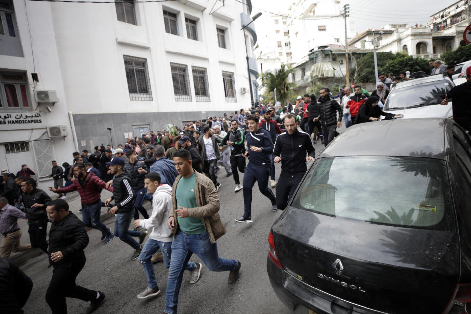Algerian demonstrators clash with security forces as they take to the streets in the capital Algiers to reject the presidential elections, in Algeria, Thursday, Dec. 12, 2019. Five candidates have their eyes on becoming the next president of Algeria _ without a leader since April _ in Thursday's contentious election boycotted by a massive pro-democracy movement. (AP Photo)