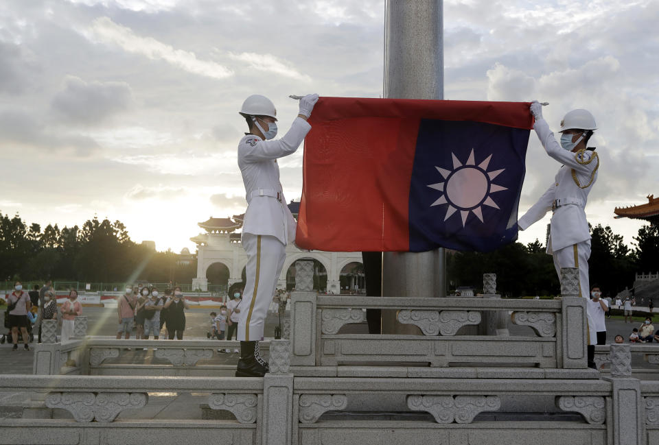 FILE - Two soldiers fold the national flag during the daily flag ceremony in Liberty Square of Chiang Kai-shek Memorial Hall in Taipei, Taiwan, Saturday, July 30, 2022. A delegation of U.S. lawmakers met with Taiwan's President Tuesday, Feb. 21, 2023, as part of an ongoing visit that comes at a tense moment between the U.S. and China, who have spent weeks trading accusations over a spy balloon. (AP Photo/Chiang Ying-ying, File)