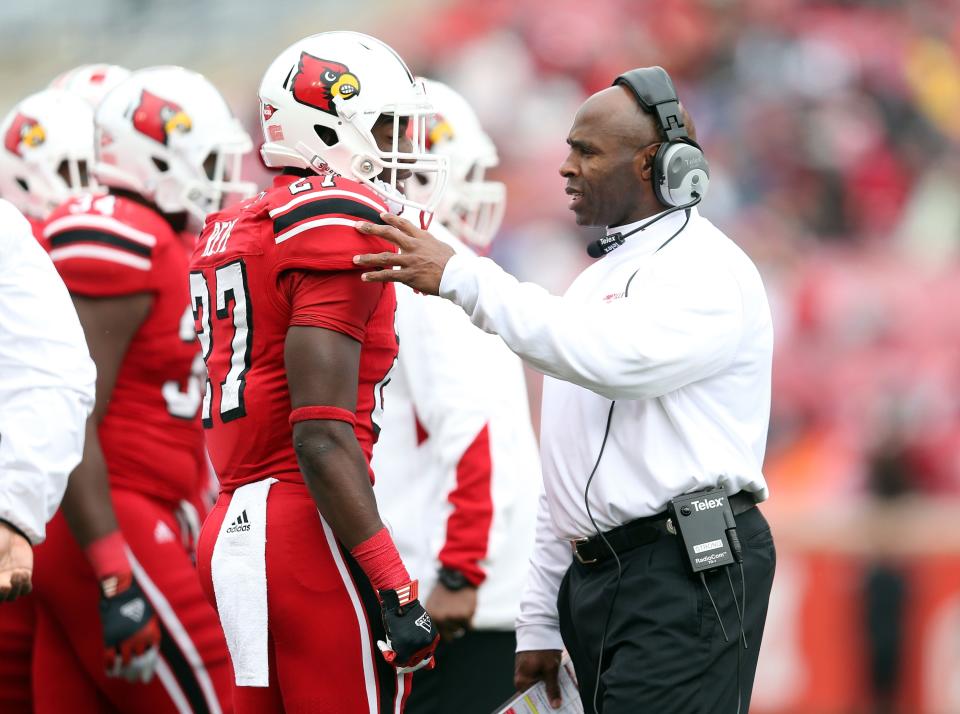 Charlie Strong the head coach of the Louisville Cardinals talks with Jermaine Reve #27 during the game against the Temple Owls at Papa John's Cardinal Stadium on November 3, 2012 in Louisville, Kentucky. (Photo by Andy Lyons/Getty Images)
