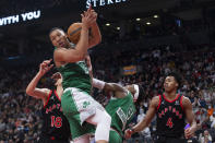 Boston Celtics' Grant Williams, top, grabs a defensive rebound as Toronto Raptors' Scottie Barnes looks on during the second half of an NBA basketball game Sunday, Nov. 28, 2021 in Toronto. (Chris Young/The Canadian Press via AP)