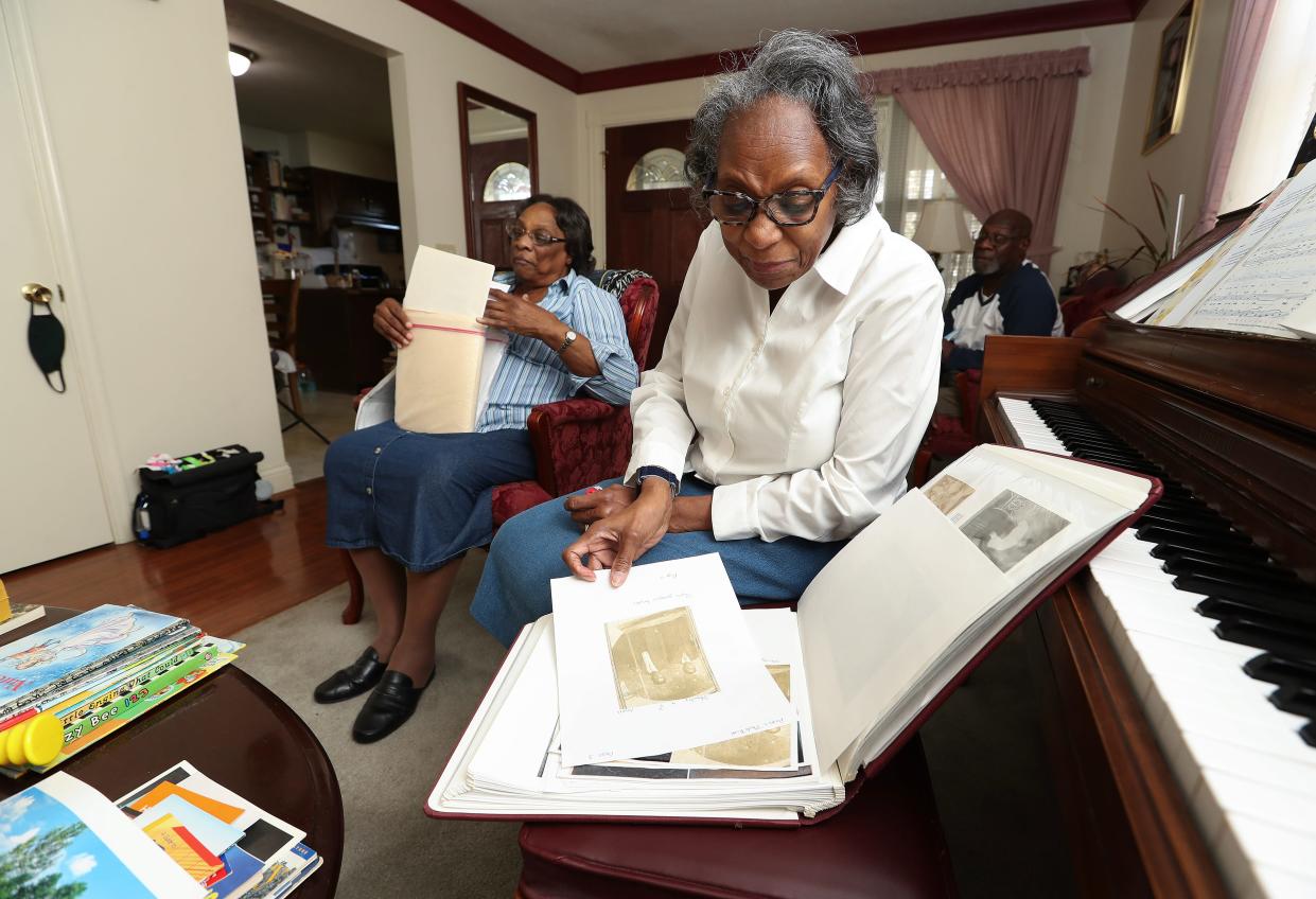 Gladys Johnson Dorsey, 73, right, looks through a photo album as her sister Ruth Johnson-Watts, 81, examines historical documents at Johnson-Watts' home in Cincinnati on March 20, 2024. They are descendants of Oliver Lewis, the first jockey to win the Kentucky Derby in 1875.