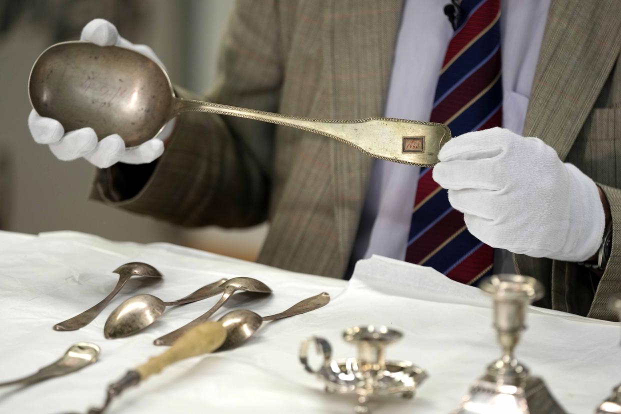 Matthias Weniger, curator of the Bavarian National Museum, lifts one of the 111 silver objects stolen by the Nazis from the Jews during the Third Reich, in Munich, Germany, Saturday, June 10, 2023. (AP Photo/Matthias Schrader)