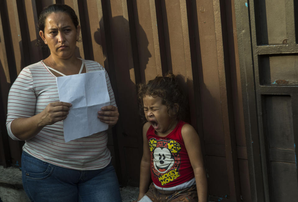 Ana Isabel, and her daughter, Breidi, wait in line outside the Mexican Commission for Migrant Assistance office to get the documents needed that allows them to stay in Mexico, in Tapachula, early Thursday, June 20, 2019. The flow of migrants into southern Mexico has seemed to slow in recent days as more soldiers, marines, federal police, many as part of Mexico's newly formed National Guard, deploy to the border under a tougher new policy adopted at a time of increased pressure from the Trump administration. (AP Photo/Oliver de Ros)