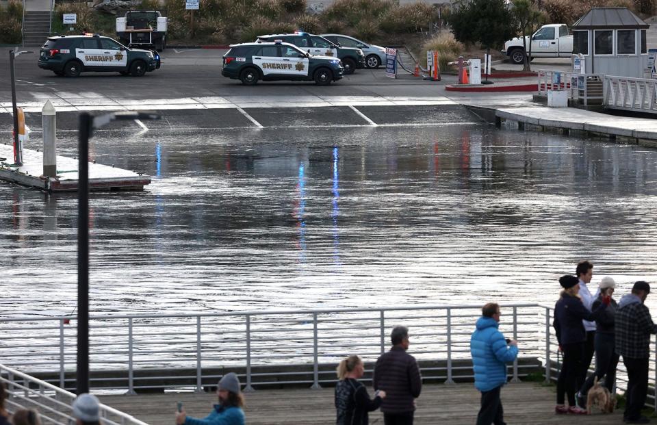 Sheriff's deputies stand by after closing the harbor launch ramp as a tsunami surge flows through the Santa Cruz Small Craft harbor on Saturday, Jan. 15, 2022 in Santa Cruz, Calif. 