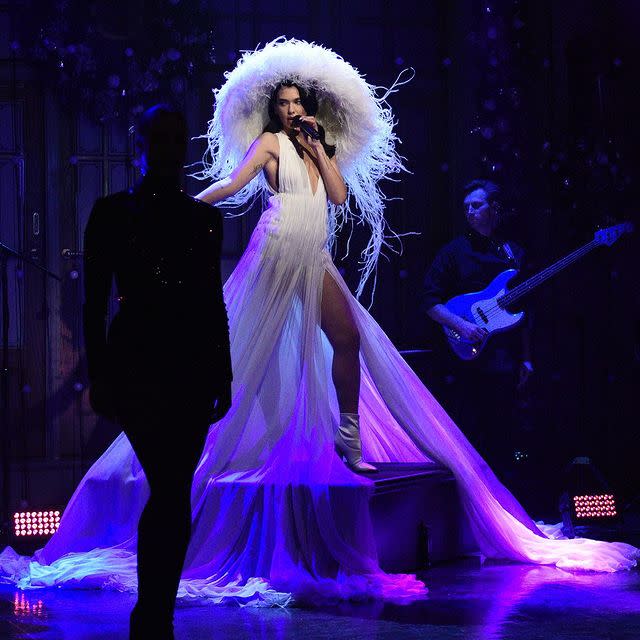 <p>Dua Lipa was truly levitating in this dreamy couture moment for her musical performance on Saturday Night Live. The singer stunned in an ethereal ivory Valentino Haute Couture 2020 collection plissé gown, paired with a matching <a href="https://www.dazeddigital.com/tag/philip-treacy" rel="nofollow noopener" target="_blank" data-ylk="slk:Phillip Treacy;elm:context_link;itc:0;sec:content-canvas" class="link ">Phillip Treacy</a> for Valentino white oversized feathery hat and finished off with white pointed leather boots. </p><p><a class="link " href="https://www.net-a-porter.com/en-gb/shop/designer/valentino" rel="nofollow noopener" target="_blank" data-ylk="slk:SHOP VALENTINO NOW;elm:context_link;itc:0;sec:content-canvas">SHOP VALENTINO NOW</a></p><p><a href="https://www.instagram.com/p/CJCCA-wr7hY/" rel="nofollow noopener" target="_blank" data-ylk="slk:See the original post on Instagram;elm:context_link;itc:0;sec:content-canvas" class="link ">See the original post on Instagram</a></p>