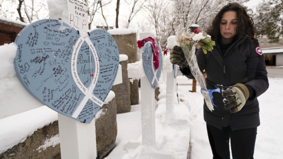 Rachel Ferrante, executive director of the Maine Mill, gathers items from a makeshift memorial for the victims of an October mass shooting in Lewiston, Maine, Tuesday, Dec. 5, 2023.(Robert F. Bukaty/AP)