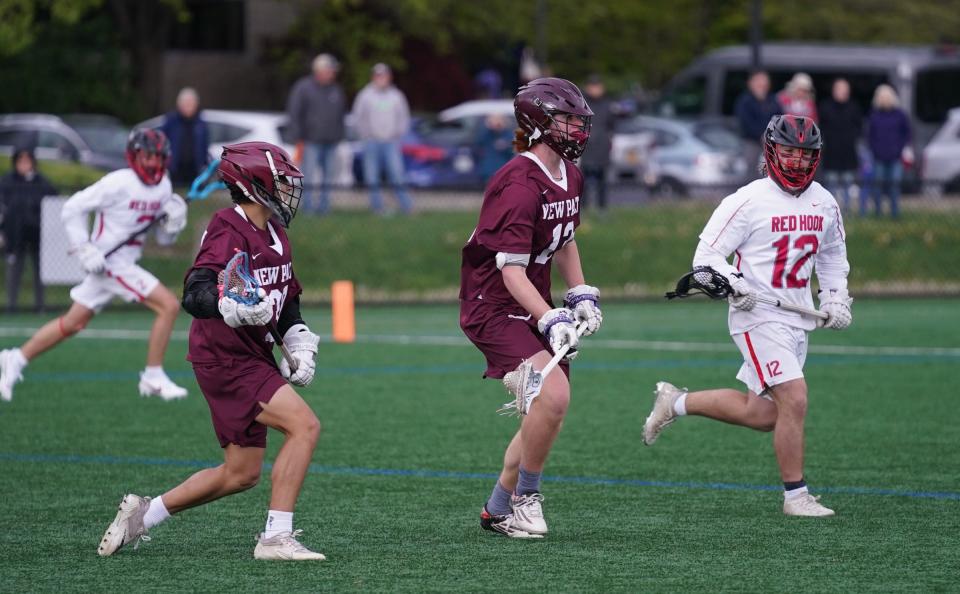 Red Hook's Mikey Mrzyglod draws the attention of two New Paltz defenders during a May 3, 2023 boys lacrosse game.