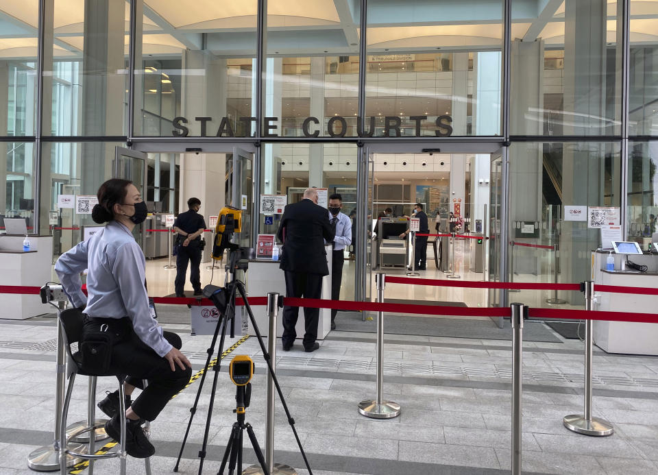 A security officer is seen outside the State Courts in Singapore, Monday, Feb. 15, 2021. British citizen Skea Nigel The Briton man pleaded guilty on Monday to violating a coronavirus quarantine order in Singapore to visit his fiancee. (AP Photo/Annabelle Liang)