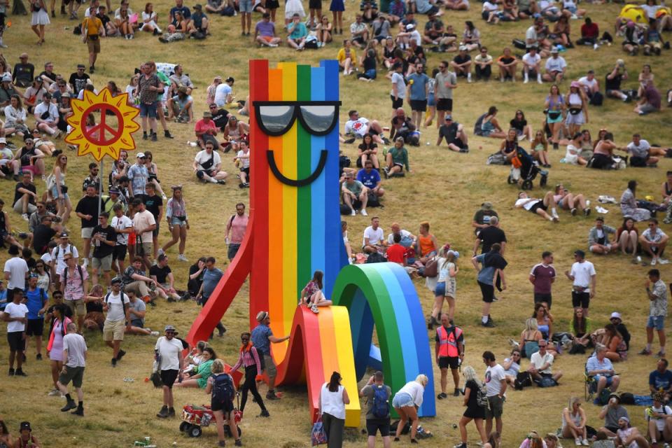 Festivalgoers mingle in a field (AFP via Getty Images)