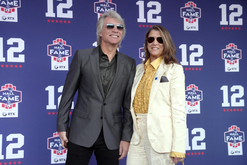 Musician Jon Bon Jovi, left, stands with his wife, Dorothea Hurley, right, as they arrive for the Patriots Hall of Fame induction ceremony for former New England Patriots quarterback Tom Brady, at Gillette Stadium, Wednesday, June 12, 2024, in Foxborough, Mass. (AP Photo/Steven Senne)