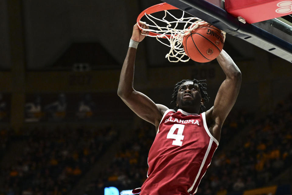 Oklahoma guard Joe Bamisile (4) dunks the ball against West Virginia during the second half of an NCAA college basketball game in Morgantown, W.Va., Saturday, Feb. 4, 2023. (AP Photo/William Wotring)