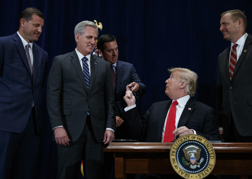 President Donald Trump has a pen to Rep. Devin Nunes, R-Calif., after signing a "Presidential Memorandum Promoting the Reliable Supply and Delivery of Water in the West," during a ceremony, Friday, Oct. 19, 2018, in Scottsdale, Ariz. Also standing behind the president from left, Rep. David Valadao, R-Calif., Majority Leader Kevin McCarthy, R-Calif., and Rep. Jeff Denham, R-Calif. (AP Photo/Carolyn Kaster)