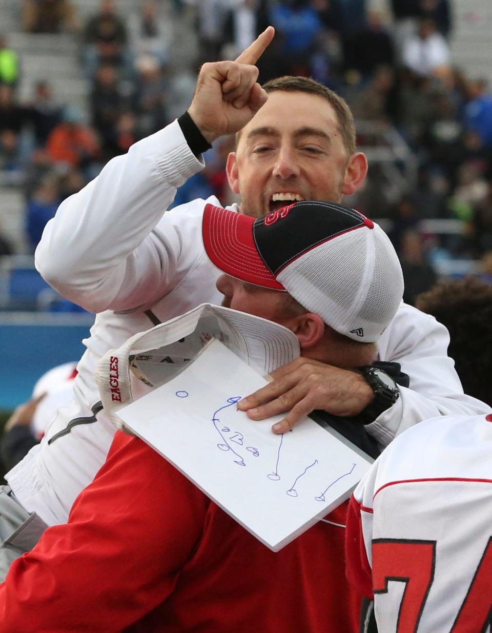 Smyrna assistant coach Mike Marks is hoisted by fellow coach Chris Sfamurri after Smyrna's 30-27 win in the DIAA Division I state title game at Delaware Stadium in 2017.