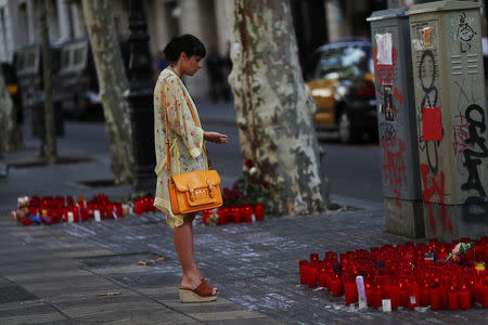 A woman reacts at an impromptu memorial where a van crashed into pedestrians at Las Ramblas in Barcelona, Spain, August 20, 2017. REUTERS/Susana Vera