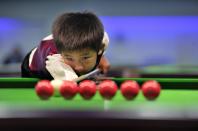 Three-year-old Wang Wuka practices before playing snooker with seven-time World Championship winner Stephen Hendry of Britain in Beijing September 23, 2013. Wuka's father Wang Yin, a snooker fan, has been teaching his son the sport for more than two years. The boy, who vows to be a top snooker player, undergoes five hours of training daily to shoot the balls with precision. (REUTERS/Stringer)