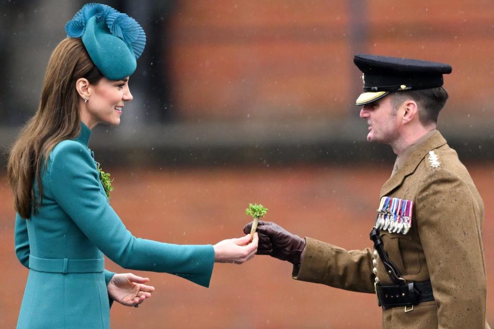 Catherine, Princess of Wales presents a traditional sprig of shamrock to an Officer during the St. Patrick's Day Parade at Mons Barracks on March 17, 2023 in Aldershot, England. Catherine, Princess of Wales attends the parade for the first time as Colonel of the Regiment succeeding The Prince of Wales, the outgoing Colonel. (