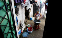 María Teresa Carballo corta repollo para preparar los platillos que vende en el mercado de Santa Ana, El Salvador, el 10 de octubre del 2019. Carballo vive en un barrio controlado por una pandilla y el mercado se encuentra en territorio de otra, lo que la expone a numerosos peligros. (AP Photo/Eduardo Verdugo)