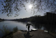 A man walks along the Saone river during a nationwide confinement to counter the COVID-19, on the Barbe island in Lyon, central France, Tuesday, April 7, 2020. The new coronavirus causes mild or moderate symptoms for most people, but for some, especially older adults and people with existing health problems, it can cause more severe illness or death. (AP Photo/Laurent Cipriani)